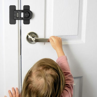 bloque porte bebe noir petite fille rose essaie ouvrir porte blanche poignée ronde cadre
