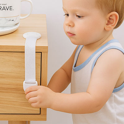 bloque porte blanc sangle bébé blond essaie ouvrir meuble bouton-pression