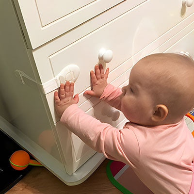 bloque porte blanc sangle bébé rose essaie ouvrir meuble angle