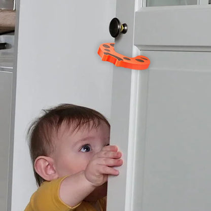 bloque porte forme crabe orange bébé jaune regarde porte entrouverte