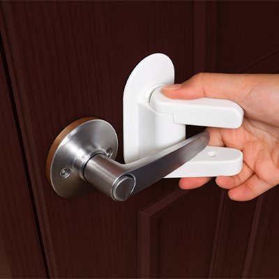 bloquer les portes pour bebe blanc main adulte installe poignée levier ronde argentée porte marron