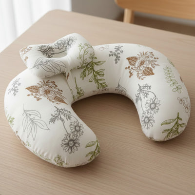 coussin-allaitement-motifs-botaniques-feuilles-vue-seul-table-bois-fond-clair