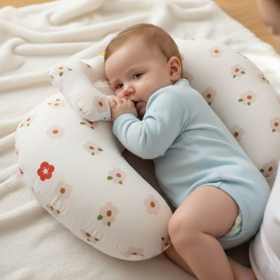 coussin allaitement motifs fleurs bébé body bleu allongé fond blanc lit