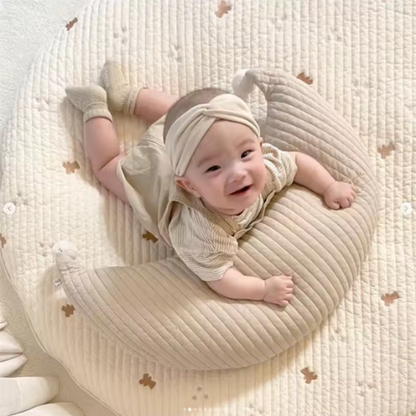 coussin d'allaitement forme croissant beige bébé souriant allongé dessus