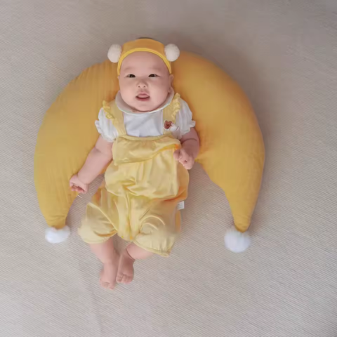 coussin d'allaitement forme croissant jaune bébé habillé vue dessus