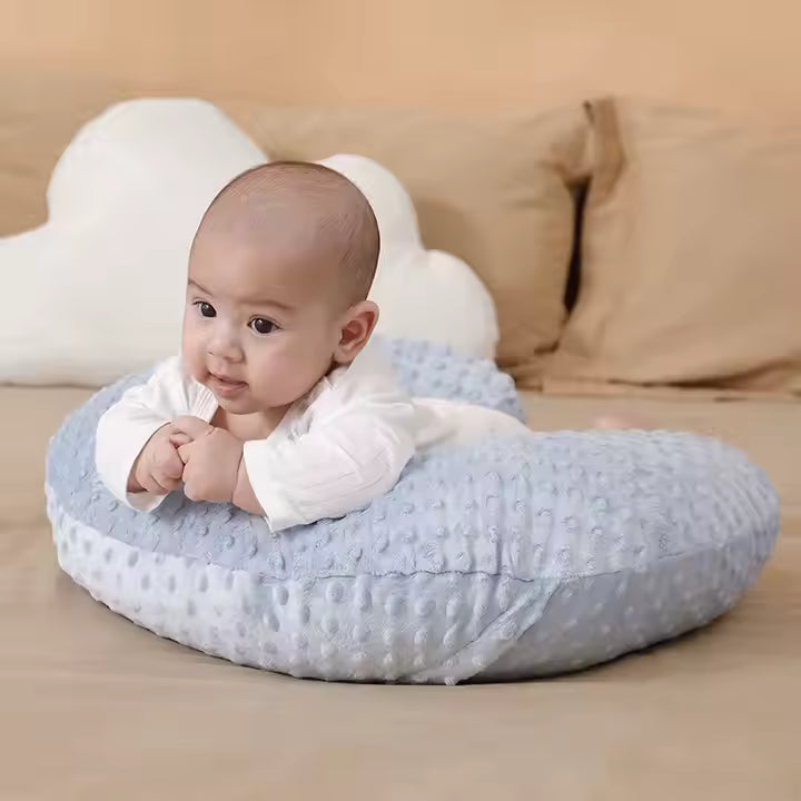 coussin d'allaitement forme U  bleu clair bébé assis fond canapé 