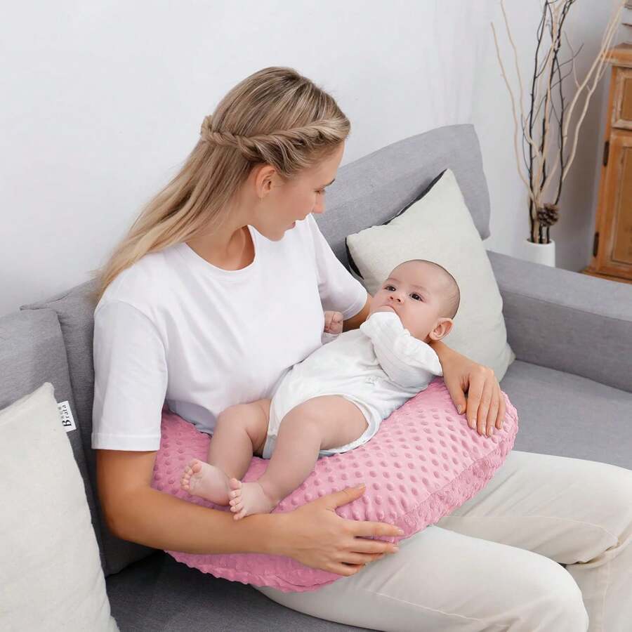 coussin d'allaitement forme U rose maman allaite bébé assis canapé